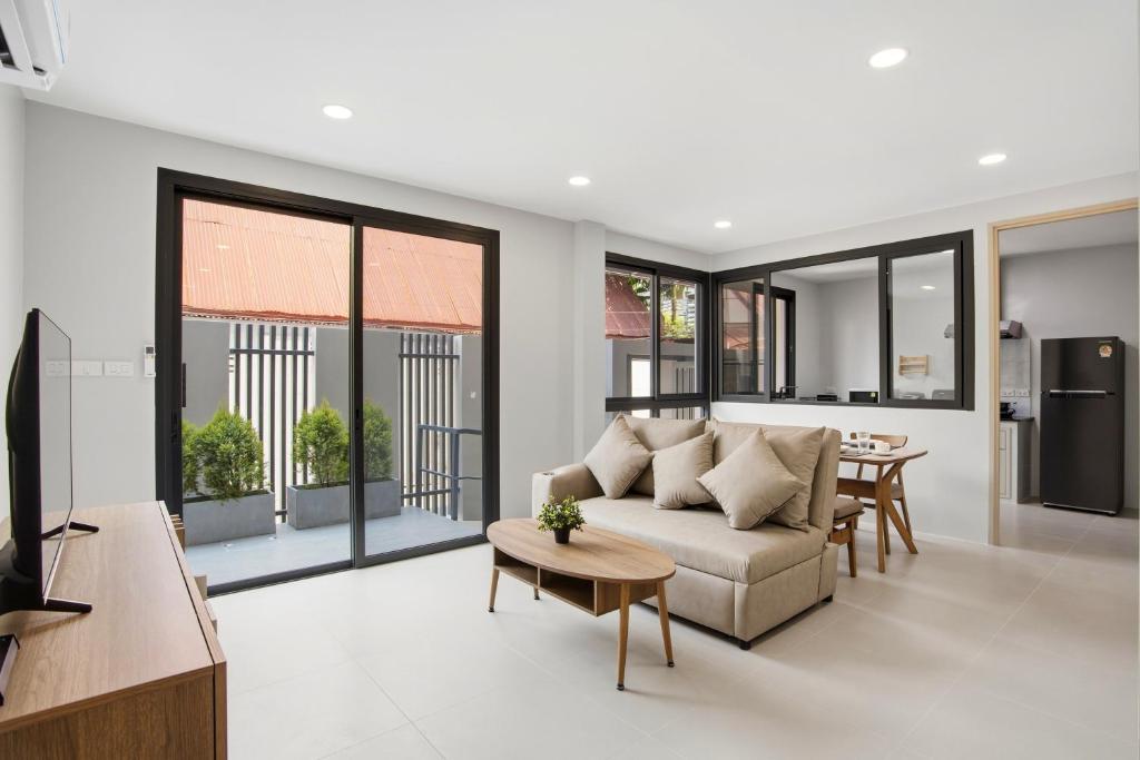 a living room with a couch and a table at Tiva Residence Bangkok in Bangkok