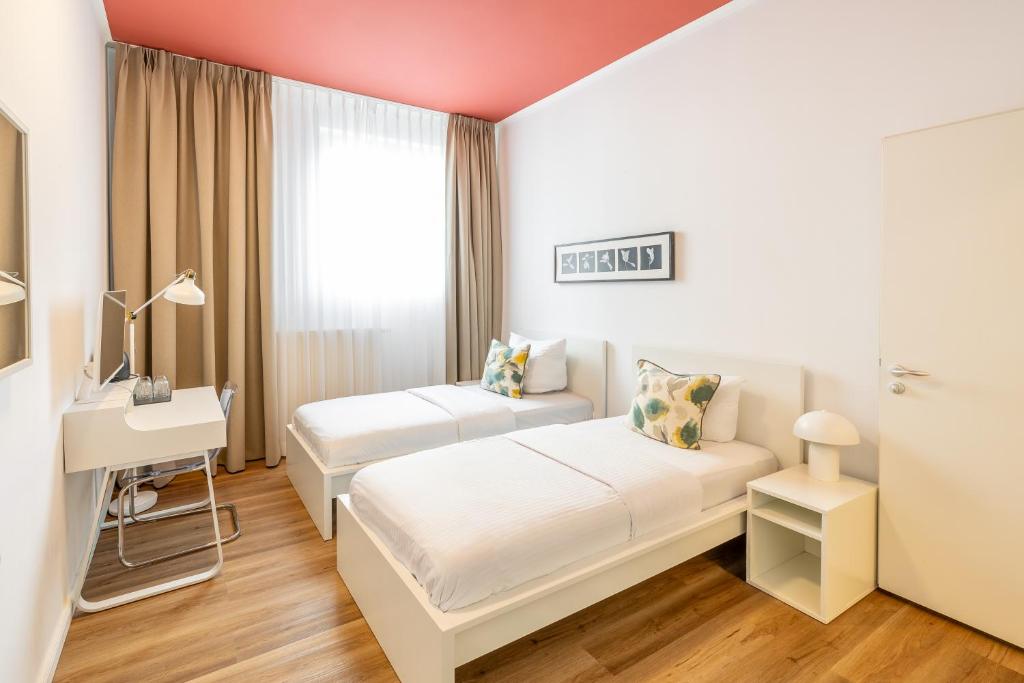 a hotel room with two beds and a window at Midi Inn Parkhotel Mitte in Berlin