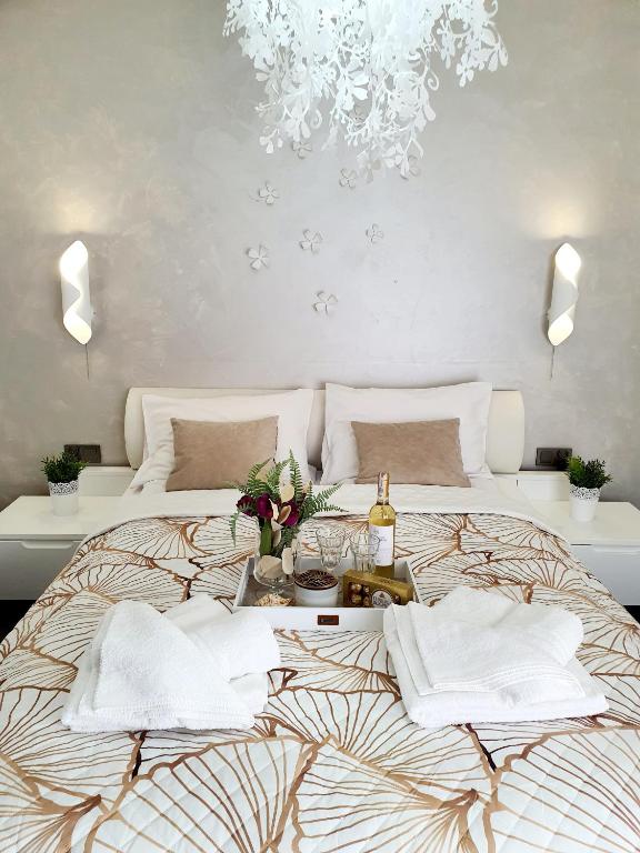 a bedroom with a large bed with a chandelier at Apartament & Spa 5 Mórz in Sianozety