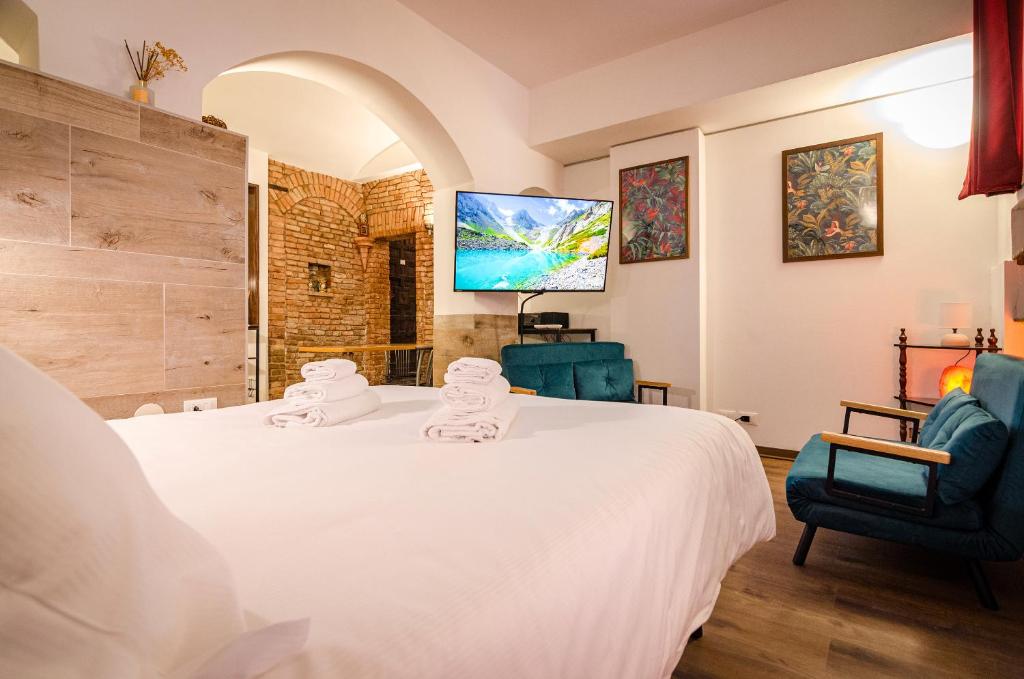 a bedroom with a large white bed and two chairs at Medieval central apartment in Bologna