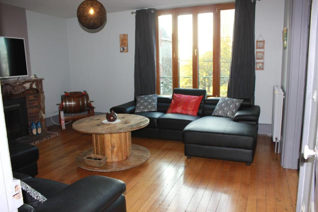 a living room with a couch and a table at Gîte with pool & Nordic bath in Monthois