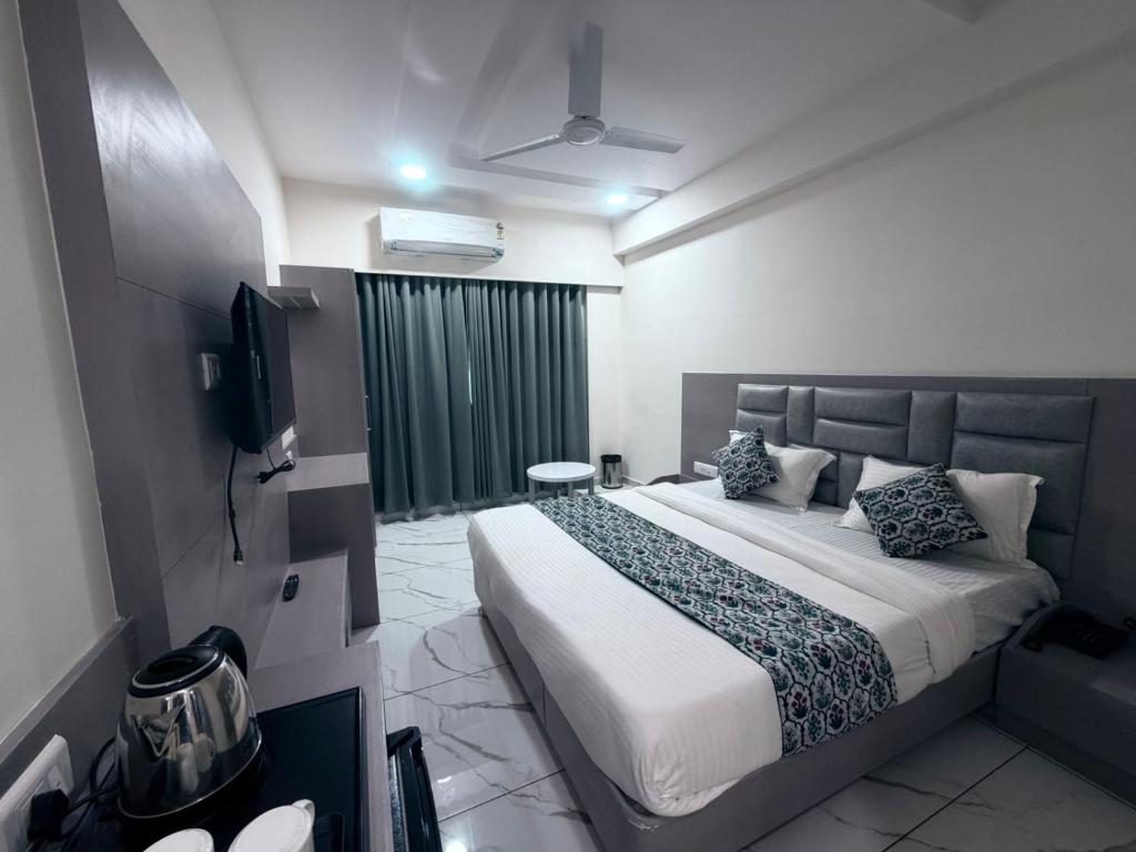 a bedroom with a large bed and a television at The 7 elevan hotel in Sānand
