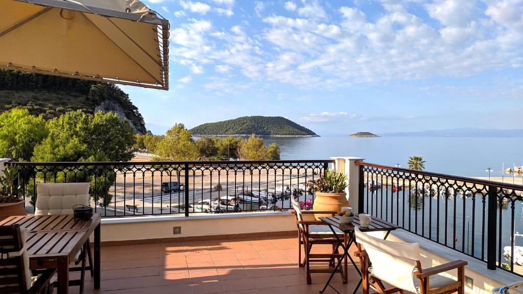 a balcony with a table and chairs and a view of the water at Lina`s Apartment & Maisonette in Neo Klima