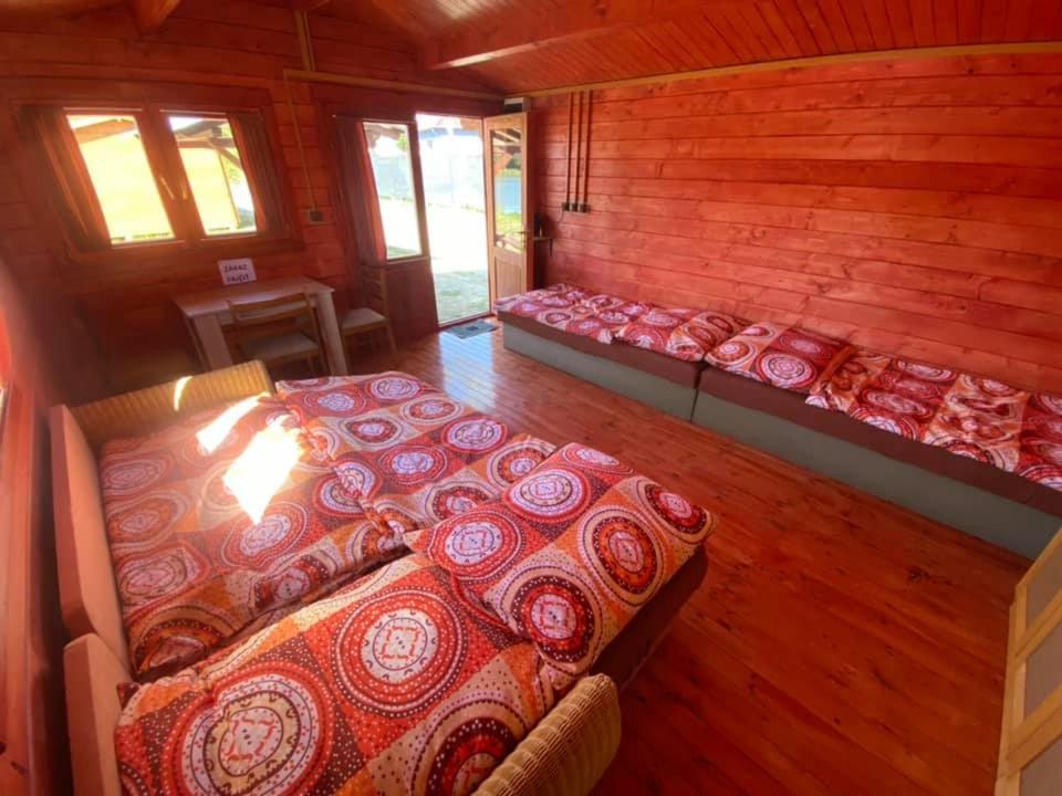 a room with several beds in a wooden cabin at Chatka pri vode aj pre rybárov 3 in Galanta