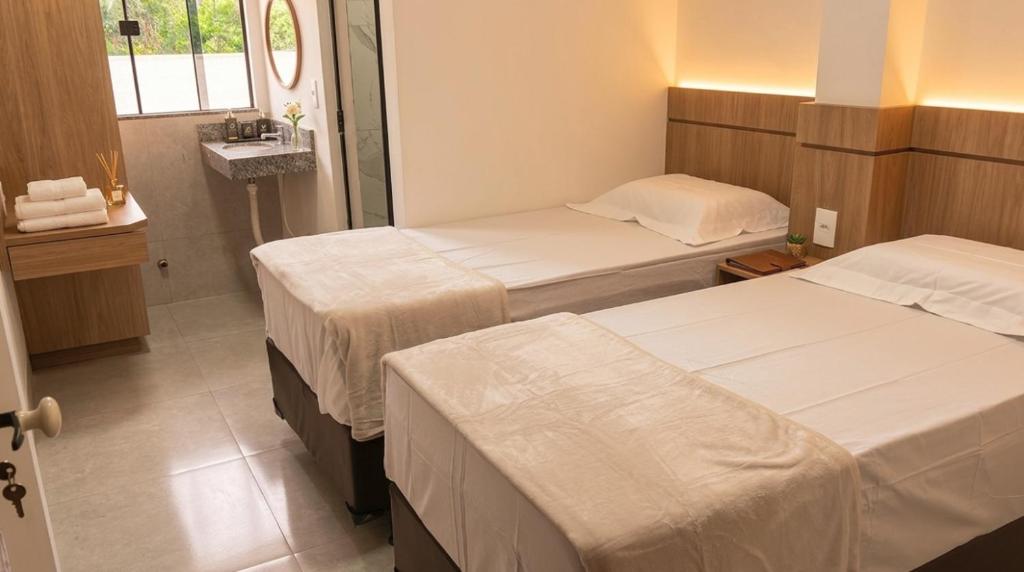 a hotel room with two beds and a window at Giacomelli Plaza Hotel in Rio Verde