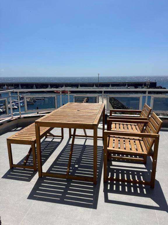 a wooden table and bench sitting on top of a roof at Ático Rocamar in La Restinga