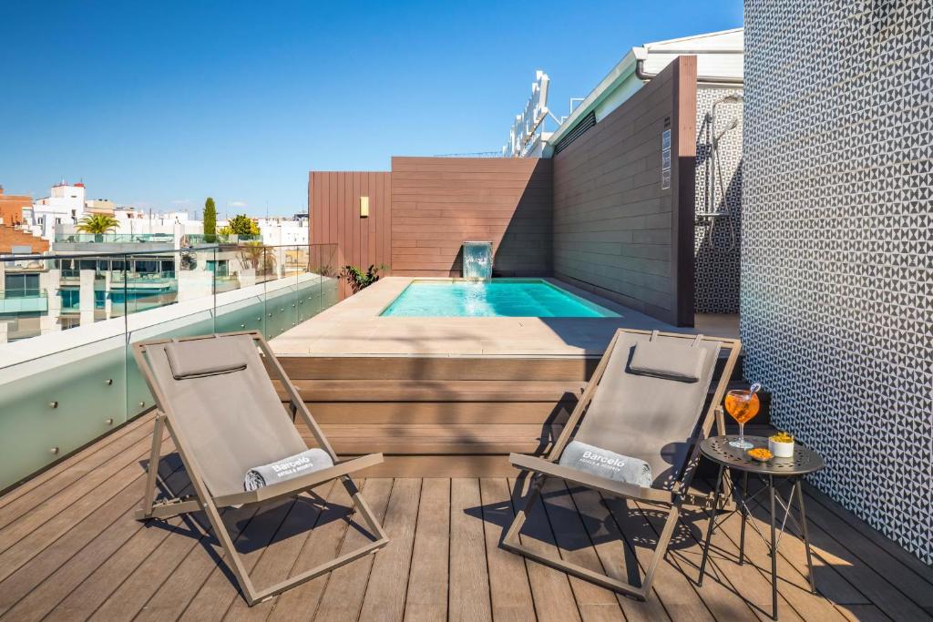 two chairs and a table on a balcony with a pool at Barceló Emperatriz in Madrid