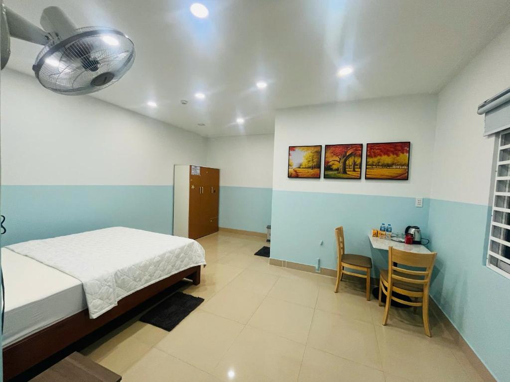 a bedroom with a bed and a table with chairs at Homestay 150 in Ho Chi Minh City