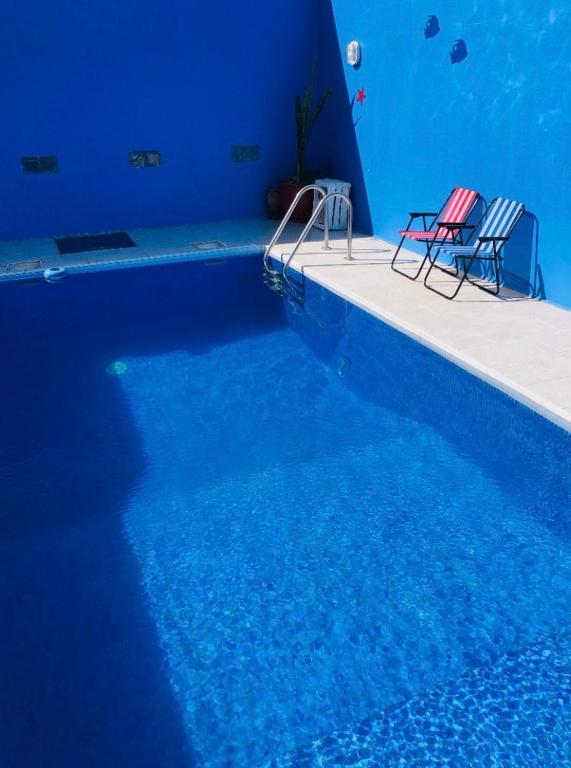two chairs sitting next to a swimming pool at Darnejma Guesthouse Oualidia in Oualidia
