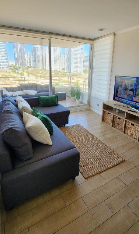 a living room with a couch and a flat screen tv at Gran espacio para descansar cerca de todo in Concón