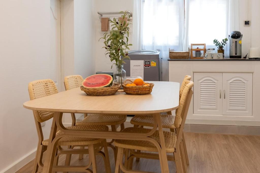 a kitchen table with a bowl of fruit on it at Allrange Home 5 bedroom for 10 guests in Chiang Mai