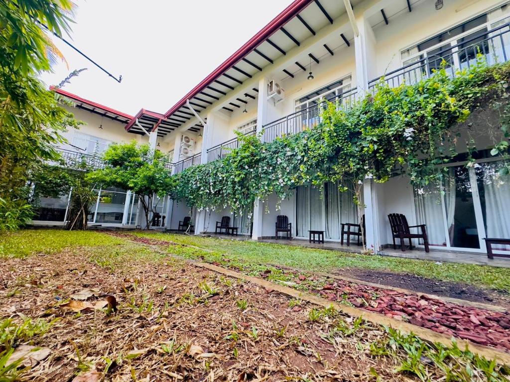 a courtyard of a building with chairs and trees at Heriance Anuradhapura in Tammannewa