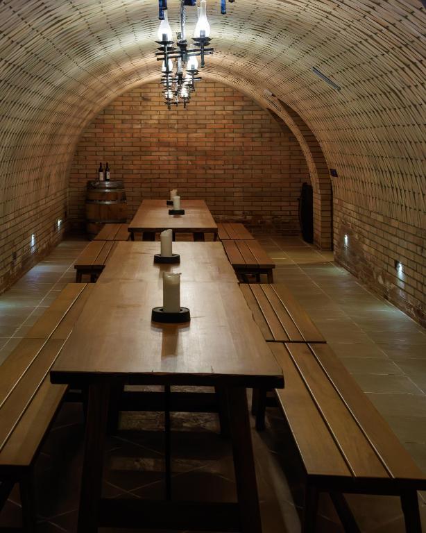 a row of tables in a room with a brick wall at Penzion Púrynky in Velké Bílovice