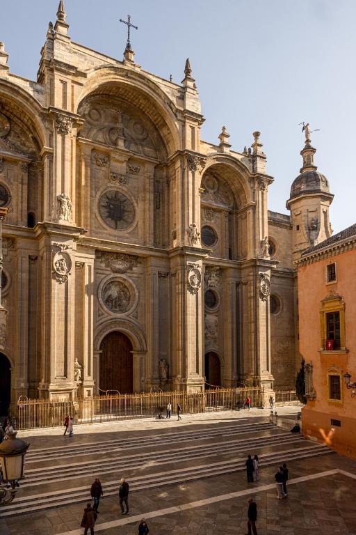 a large cathedral with people walking in front of it at Casa de la Catedral in Granada