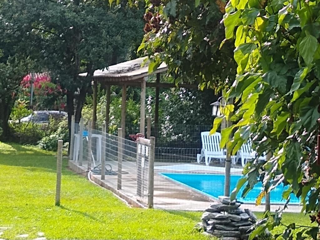 a swimming pool with a gazebo and a bench at JACARANDÁ Chalés com piscina em São José da Serra MG in Jaboticatubas