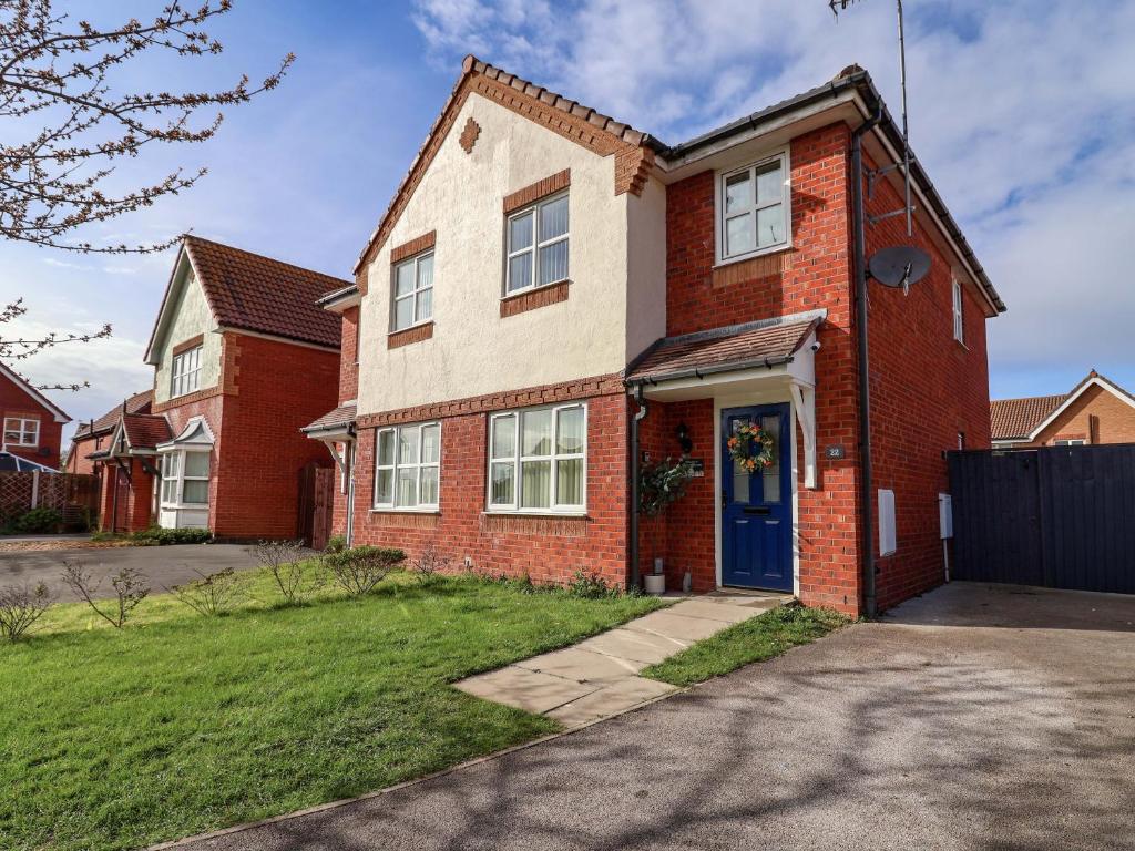 a red brick house with a blue door at The Beach Escape in Prestatyn