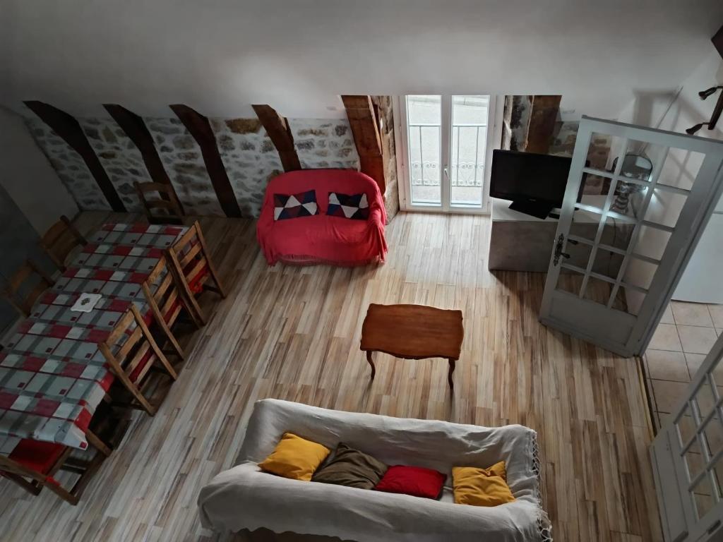 a living room with a couch and a red bag at Grand Duplex 9 pers-Centre de La Bourboule in La Bourboule