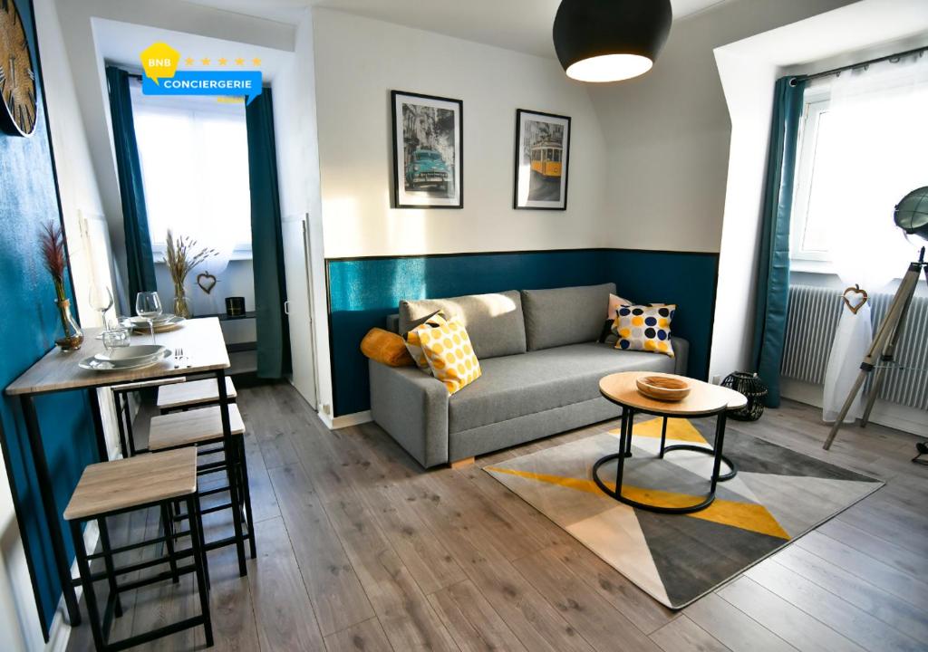 a living room with a couch and a table at Aux Toits d'Alsace in Sélestat