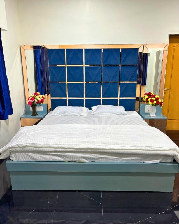 a bed with a blue headboard in a bedroom at Private Rooms In Riverstone in Karjat