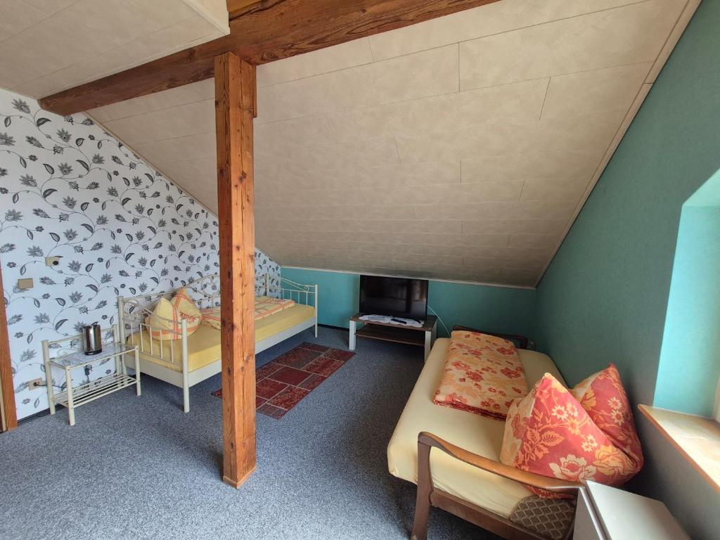a attic room with a bed and a couch at Unterkunft Julian in Waghäusel