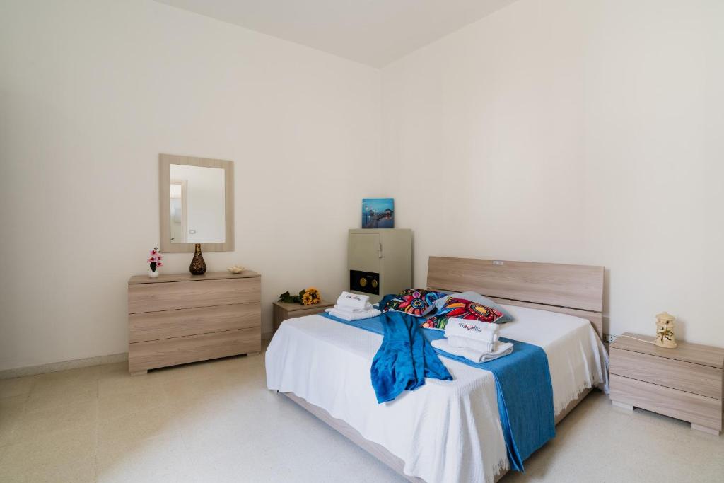 a bedroom with a bed and two dressers and a mirror at Casa Elaia 4 posti a Cannole in Cannole