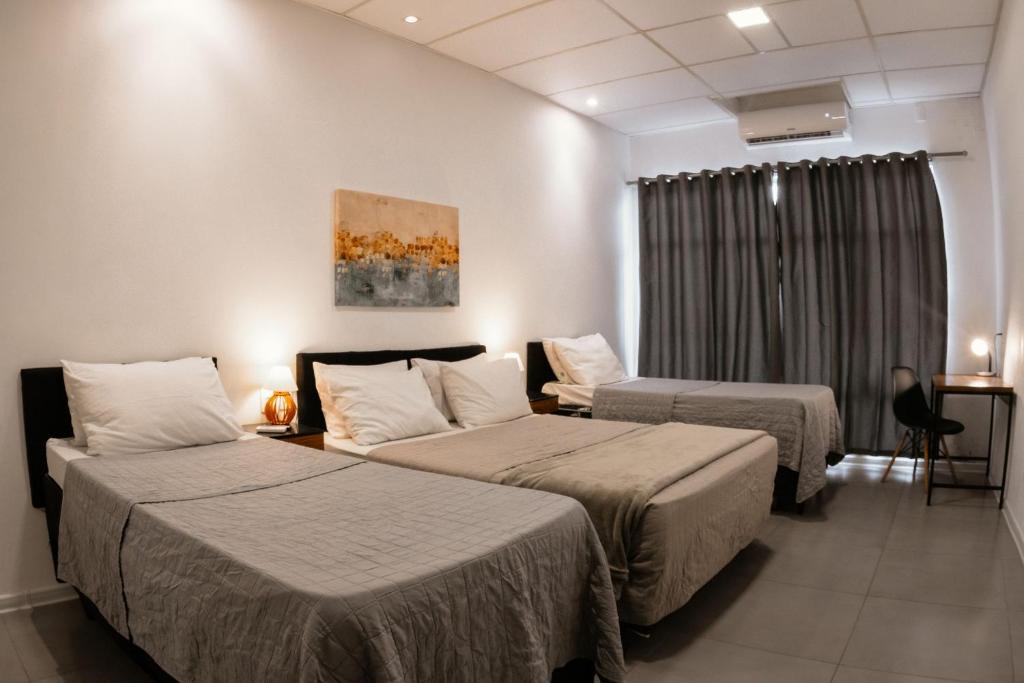 a hotel room with two beds and a window at VILLA BILAC - Large Studios close to Vila Germânica in Blumenau