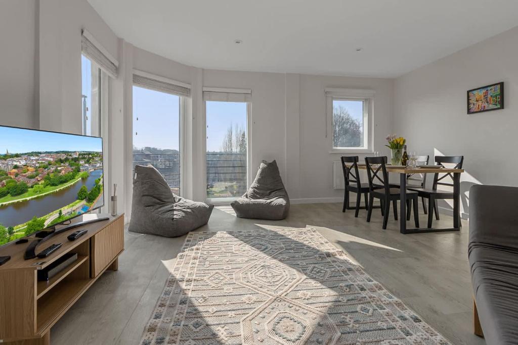 a living room with a flat screen tv and a table at Urban Heights - 2 Bed Apartment - Short Stays UK Ltd in Exeter