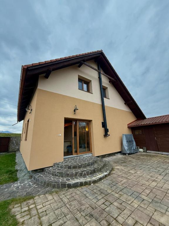 a small house with a stone driveway in front of it at Slnečný domček Sučany in Sučany