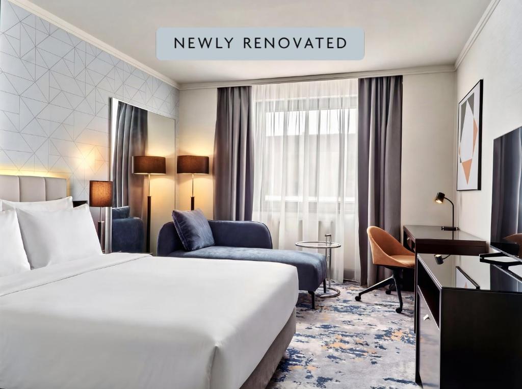 a hotel room with a large bed and a desk at Crowne Plaza Bratislava by IHG in Bratislava