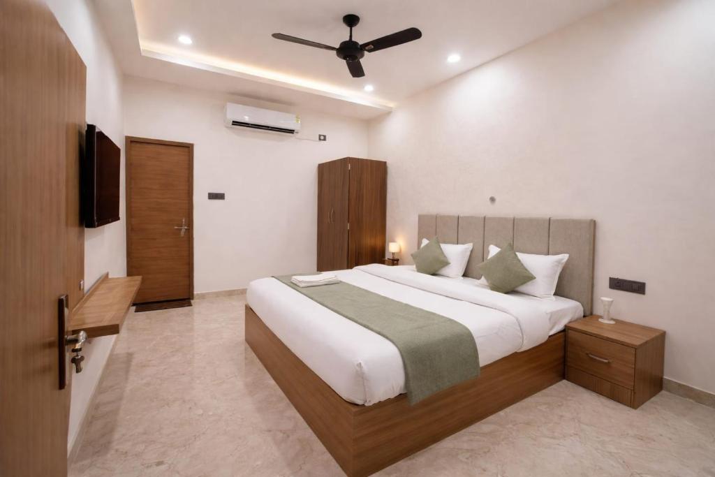 a bedroom with a large bed and a ceiling fan at The Vedam Hotels - Ram Mandir Ayodhya A unit of RL Group of Hotels Ayodhya in Ayodhya