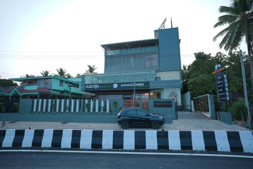 a car parked in front of a building at Gamagashree Hotel and Fine Dine in Sāgar