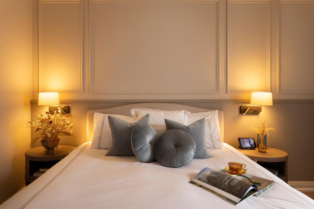a bedroom with a bed with a book and lamps at The Lansdowne Kenmare in Kenmare