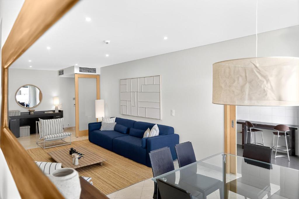 a living room with a blue couch and a table at Aquamar Pro 116 in Quarteira