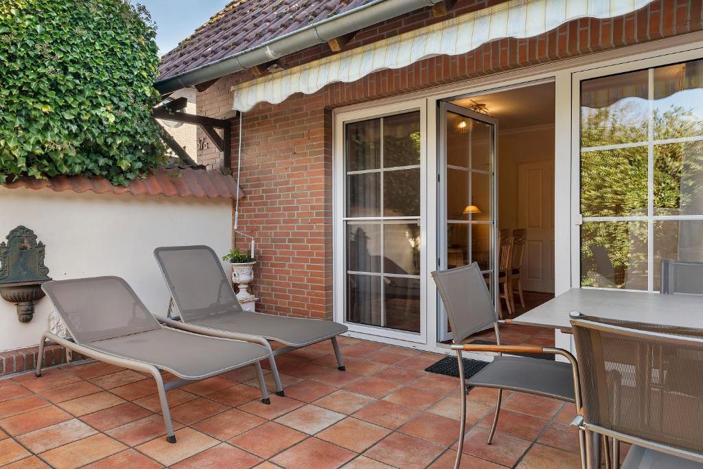 a patio with two chairs and a table at Ferienhaus Jadeblick I I in Dangast
