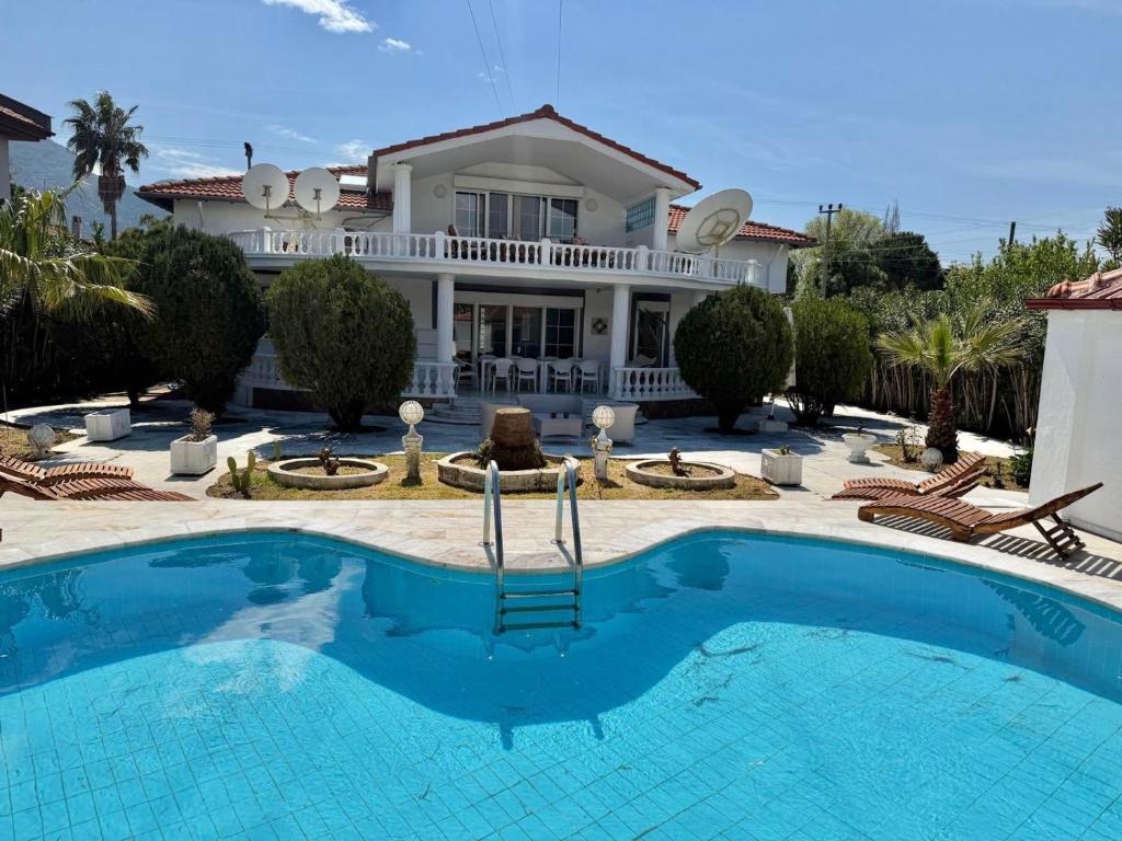 a house with a swimming pool in front of a house at Dalyan Grand Garden in Ortaca