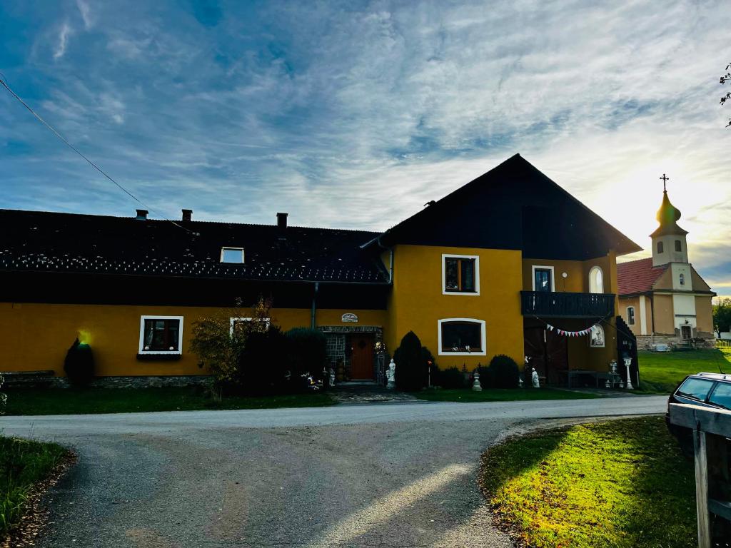 a yellow building with a church with a steeple at Einzigartige Ferienwohnungen mit 3 und 2 Schlafzimmern in Ober-Lembach