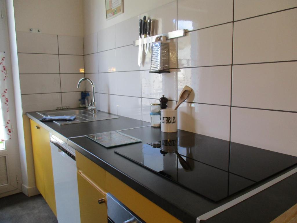 a kitchen with a black counter top and a sink at La Source - 85 m2 & terrasse privée in Orcival