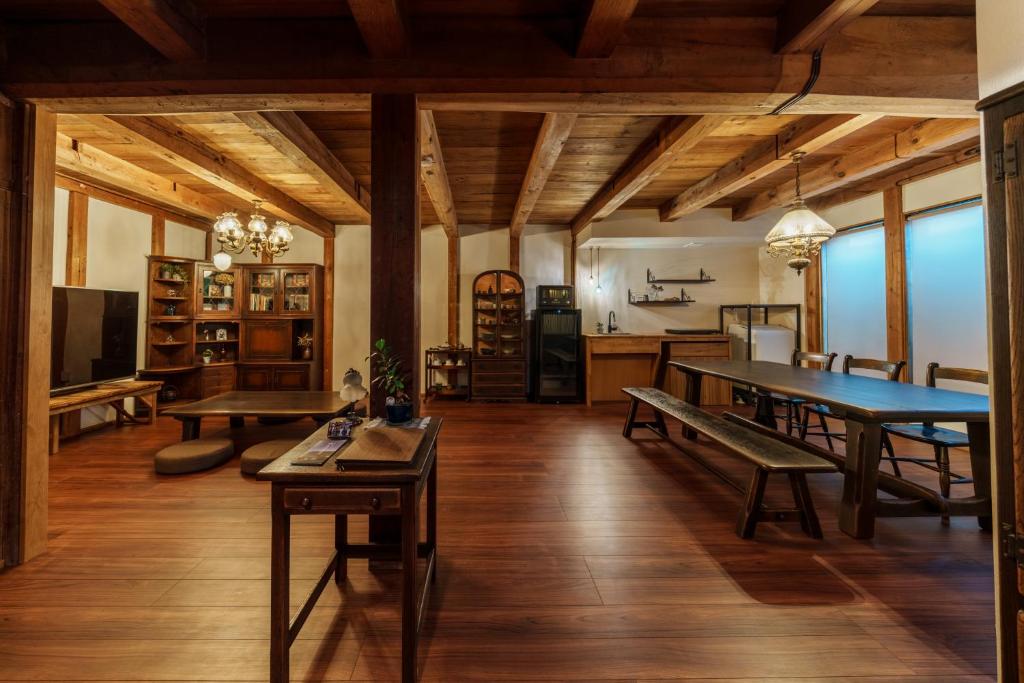 a large living room with wooden ceilings and wooden tables at NEKO no TSUKI in Takayama