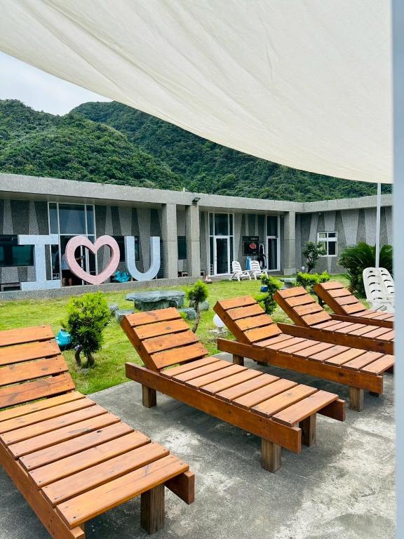a row of wooden benches in front of a building at 樂見海 in Green Island