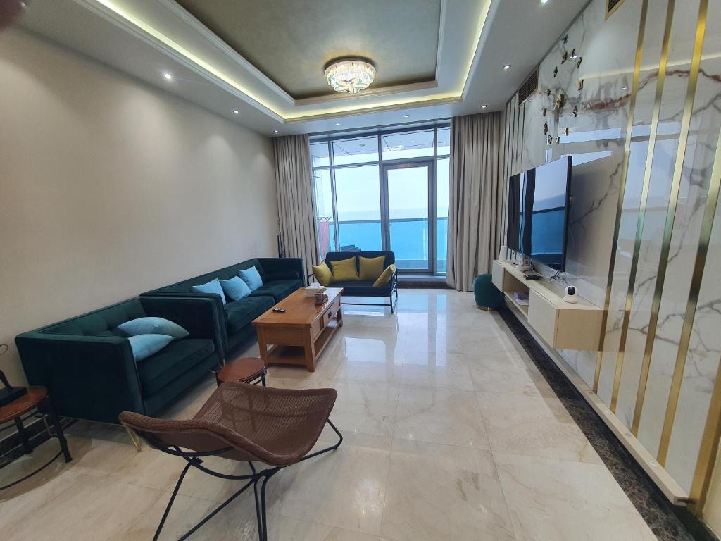 a living room with a couch and a television at Stylish 2 BR Apartment in Ajman Residences Tower 4 in Ajman 