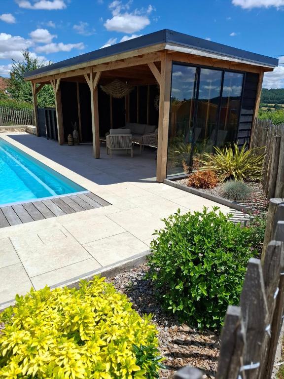 a pavilion with a pool in a yard at Chalet familial avec piscine chauffée, jeux et brasero- Morvan in Voudenay-lʼEglise