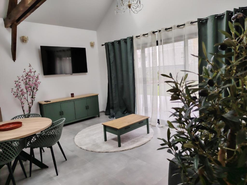 a living room with a table and a tv at Le petit marais in Le Mans