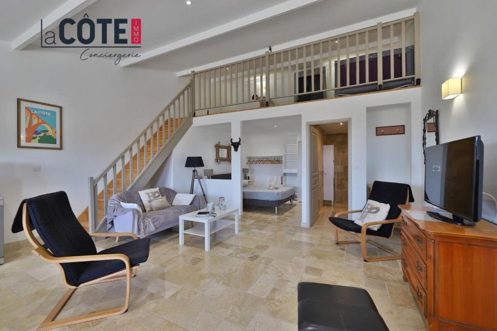a living room with a couch and a tv at A La Vaquera - Gîte équestre in Châteauneuf-lès-Martigues
