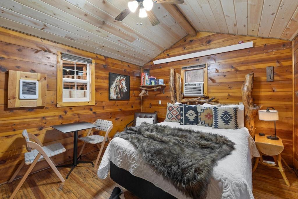 a bedroom with a bed in a log cabin at Raven Rock Getaway- Firepit Nights Getaway in Rapid City