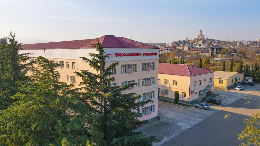 a building with a red roof on a city street at Fude Hotel T bilis第比利斯富德酒店 in Tbilisi City