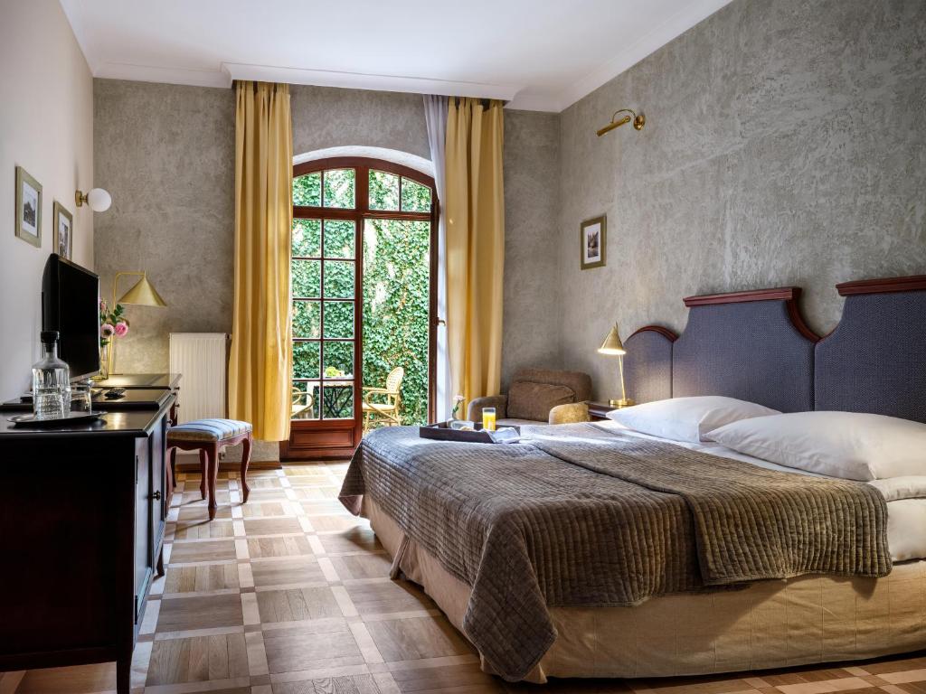 ein Schlafzimmer mit einem großen Bett und einem Fenster in der Unterkunft Hotel Maltański in Krakau