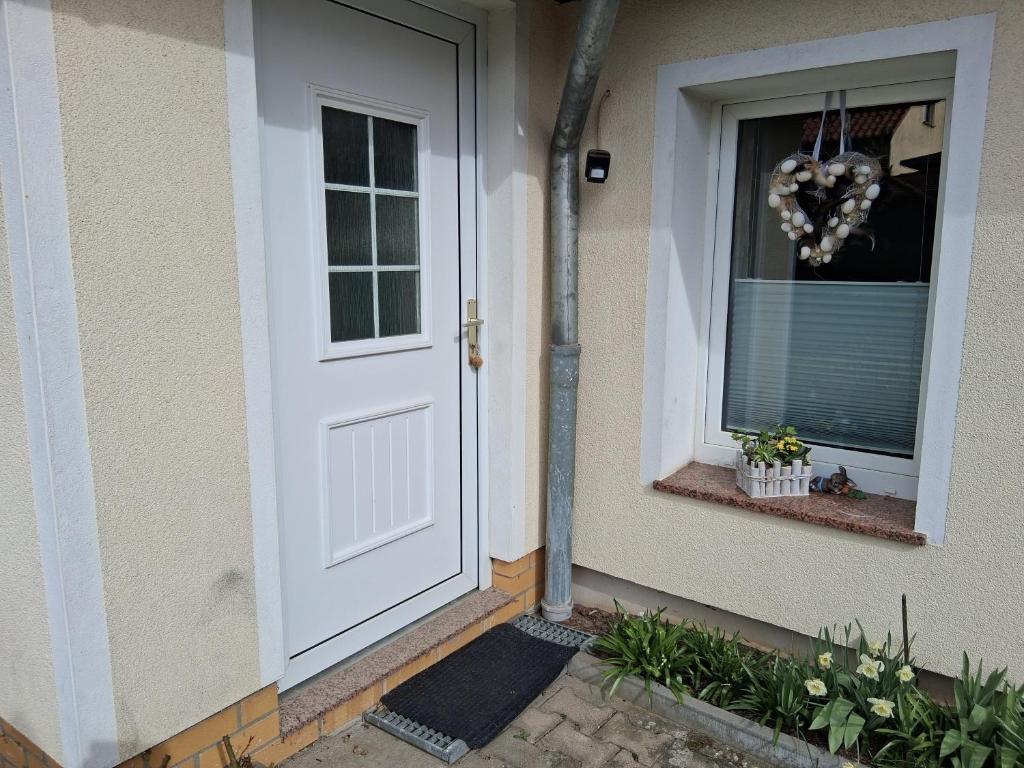 a white door on a house with a window at Bungalow Poggendorf in Eldena