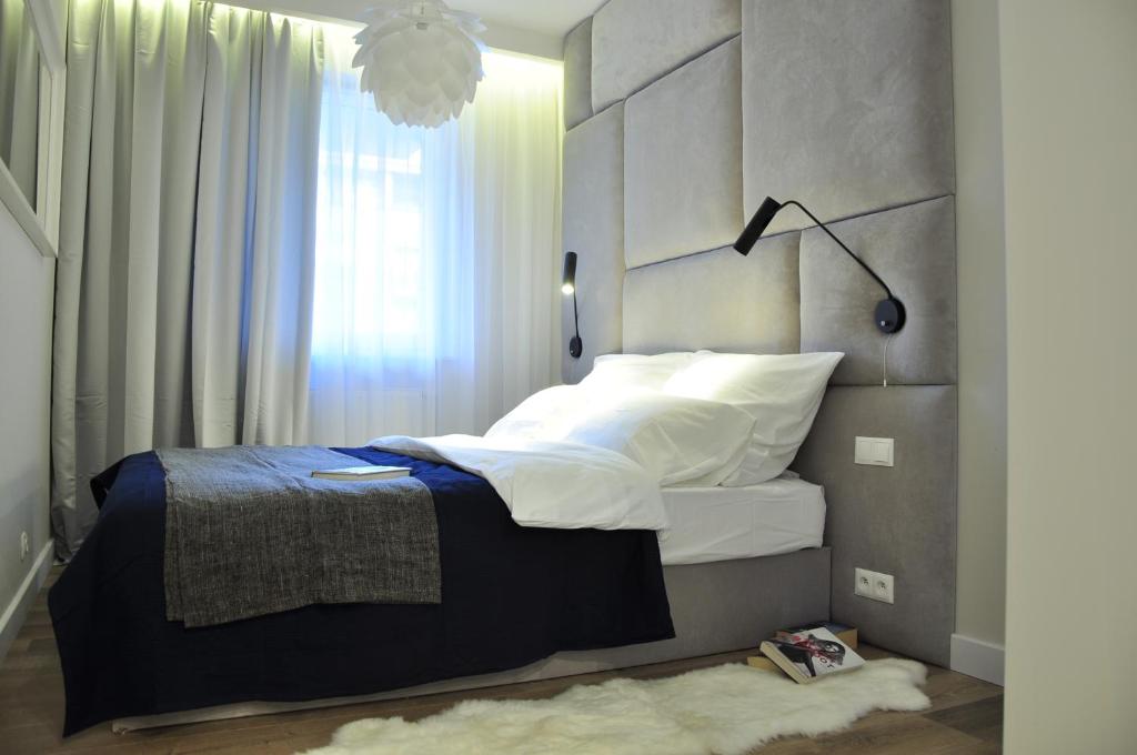 a bedroom with a large bed with a large window at City Rent Apartments in Łódź