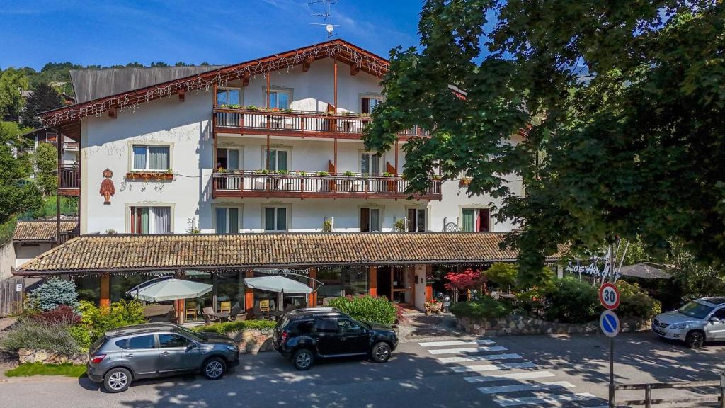 a large building with cars parked in front of it at Hotel Los Andes in Castello di Fiemme