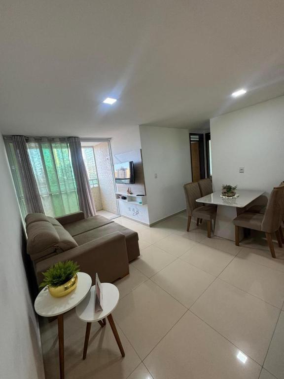 a living room with a couch and a table at 2 quartos a 300m do mar do bessa in João Pessoa